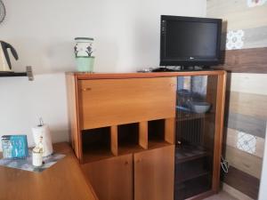 a television on top of a wooden entertainment center at Appartamento 3 del Vecchio Convento in Orino