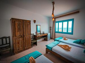 a bedroom with two beds and a desk in it at Bamboo House Hotel Dahab in Dahab