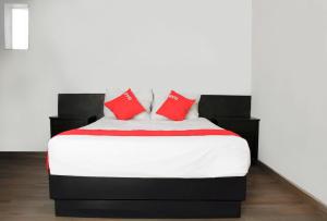 1 dormitorio con 1 cama grande con almohadas rojas en OYO Hotel Plata,Fresnillo, Zacatecas, en Fresnillo de González Echeverría