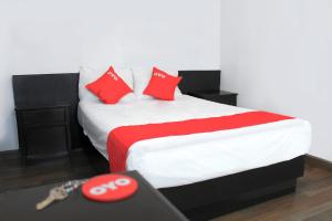 - une chambre avec un grand lit et des oreillers rouges dans l'établissement OYO Hotel Plata,Fresnillo, Zacatecas, à Fresnillo de González Echeverría