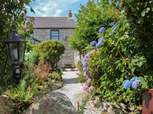 a garden in front of a house with flowers at Eldamar Cottage in Penryn