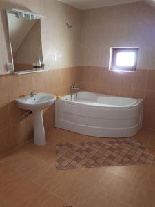 y baño con bañera y lavamanos. en Cabana ''langa brad'' en Cavnic