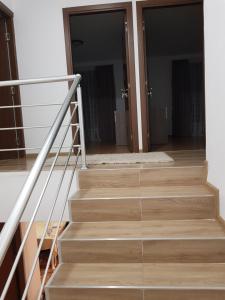 Una escalera que conduce a una habitación con puertas de cristal en Cabana ''langa brad'' en Cavnic