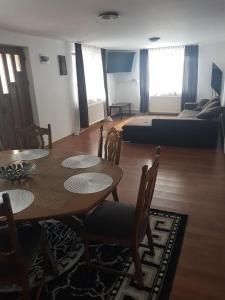 sala de estar con mesa, sillas y sofá en Cabana ''langa brad'' en Cavnic