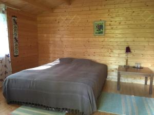 a bedroom with a bed in a log cabin at Voosemetsa Turismitalu in Voose