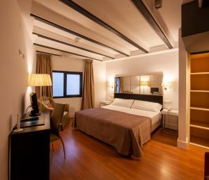 a bedroom with a bed and a desk and a chair at YIT El Postigo in Úbeda