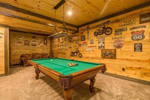un tavolo da biliardo in una stanza con pareti in legno di Northwoods Log Cabin - 3 acre retreat! a Webb Lake