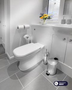 a white bathroom with a toilet and a window at Maidenhead - 1 Bed Modern Flat - Private Entrance in Maidenhead