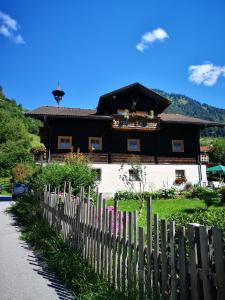 a wooden house with a fence in front of it at Pension Schlager Taxerhof in Bad Hofgastein