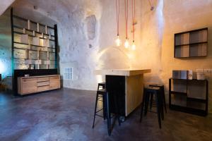 a kitchen with a counter and stools in a room at Grotta Barisano in Matera