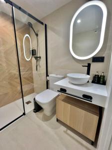 a bathroom with a toilet and a sink and a mirror at Apartamento Lucano in Córdoba +8 photos