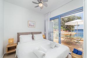 a bedroom with a large bed and a balcony at Greek Beach House B2 Lefkada in Nydri