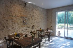 uma sala de jantar com mesas e cadeiras e uma janela em Le Moulin de Moquesouris - Chambres d'hôtes et table d'hôte em Nazelles