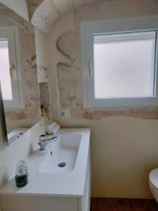 ein Bad mit einem Waschbecken und einem Fenster in der Unterkunft COMES 5 HOME in Castellana Grotte