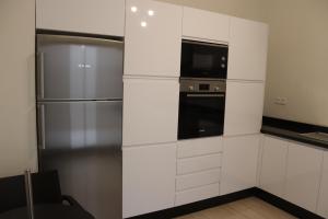 a kitchen with white cabinets and a refrigerator at Suites Appartement Midelt in Midelt