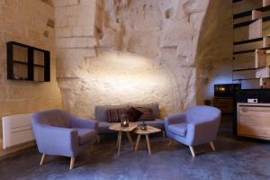 sala de estar con 2 sillas, sofá y mesa en Grotta Barisano en Matera