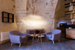 a living room with two chairs and a couch and a table at Grotta Barisano in Matera
