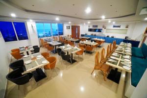 a restaurant with tables and chairs in a room at Bay View Hotel Vizag in Visakhapatnam