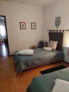 a bedroom with a bed with a headboard and pillows at Quartos da Vóvó in Avis