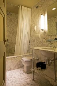 a bathroom with a toilet and a sink and a tub at Hotel Balestri - WTB Hotels in Florence