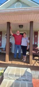 a man and a woman standing under a porch at Wolf Creek Farm B&B and Motorcycle Manor at Wolf Creek Farm in Ararat