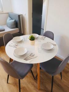 uma mesa branca com cadeiras, pratos e talheres em ND Hotels & Apartments Bottrop am Centro em Bottrop