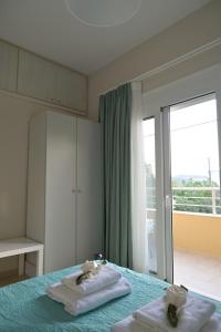 a bedroom with two towels on a bed with a window at Orange apartment in Zarós