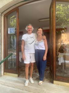 a man and a woman standing in front of a door at Albergo Magenta in Casella