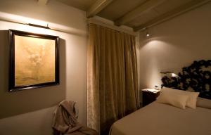 a bedroom with a bed and a window with a picture at Hotel Balestri - WTB Hotels in Florence