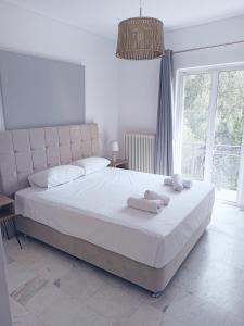 a bedroom with a large white bed with towels on it at Levante Breeze in Xirokástellon