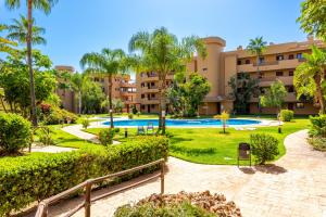 kompleks apartamentów z basenem i palmami w obiekcie Cala Azul w mieście Mijas Costa