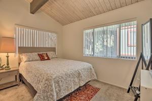a bedroom with a bed and two windows at Lake Arrowhead Cabin with Mid-Century Charm! in Lake Arrowhead