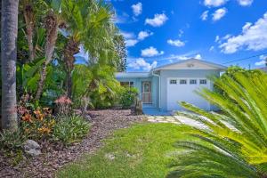 una casa blanca con palmeras y un camino de entrada en Canalfront New Port Richey Home with Boat Dock! en New Port Richey