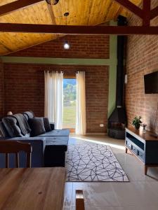 a living room with a blue couch and a brick wall at Villagio Angatu in Santo Antônio do Pinhal