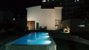 a swimming pool at night in front of a building at Vila Real House in Vila Real