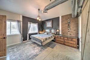 1 dormitorio con 1 cama y pared de madera en Unique Country Farmhouse Near Lake Roosevelt, en Fort Spokane