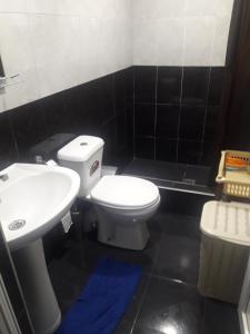 a bathroom with a white toilet and a sink at NI- KE in Tskaltubo