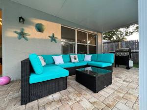 un patio con un sofá azul y una mesa en Tampa Getaway Pool House, en Tampa