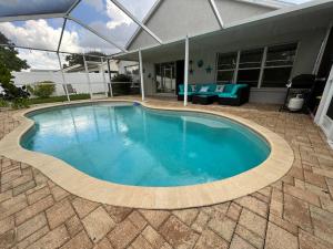 una piscina con patio y una casa en Tampa Getaway Pool House, en Tampa