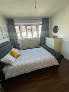 a bedroom with a bed with a yellow pillow on it at Lovely, recently refurbished four bedroom house.. in Hither Green