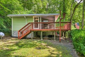 a small house with a deck in the woods at Tranquil Creekside Cottage with Deck and Lanai in Franklin