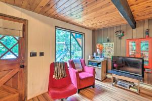 a living room with red chairs and a television at Peaceful Wooded Cabin By Mt. Baker Ski Area! in Glacier