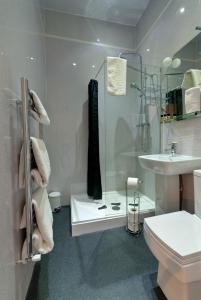 uma casa de banho com um chuveiro, um WC e um lavatório. em Lauriston & Lawton Court Hotel em Llandudno