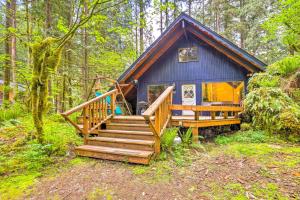 a blue tiny house in the woods with a staircase at Peaceful Wooded Cabin By Mt. Baker Ski Area! in Glacier