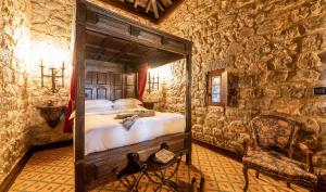 una camera da letto con un letto in un muro di pietra di Pousada Castelo de Obidos a Óbidos Altre 90 foto