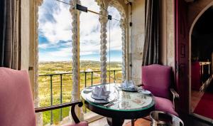 un tavolo e sedie su un balcone con vista di Pousada Castelo de Obidos a Óbidos