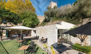 un patio con tavoli, sedie e un ombrellone di Pousada Castelo de Obidos a Óbidos
