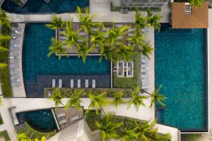 an aerial view of a resort with palm trees and a pool at Oceanfront Beach Resort - SHA Extra Plus in Patong Beach