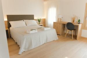 a bedroom with a bed and a desk and a chair at Casa Vettor in Valdobbiadene