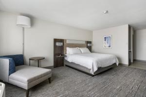 um quarto de hotel com uma cama e uma cadeira em Holiday Inn Express Peru-Lasalle Area, an IHG Hotel em Peru